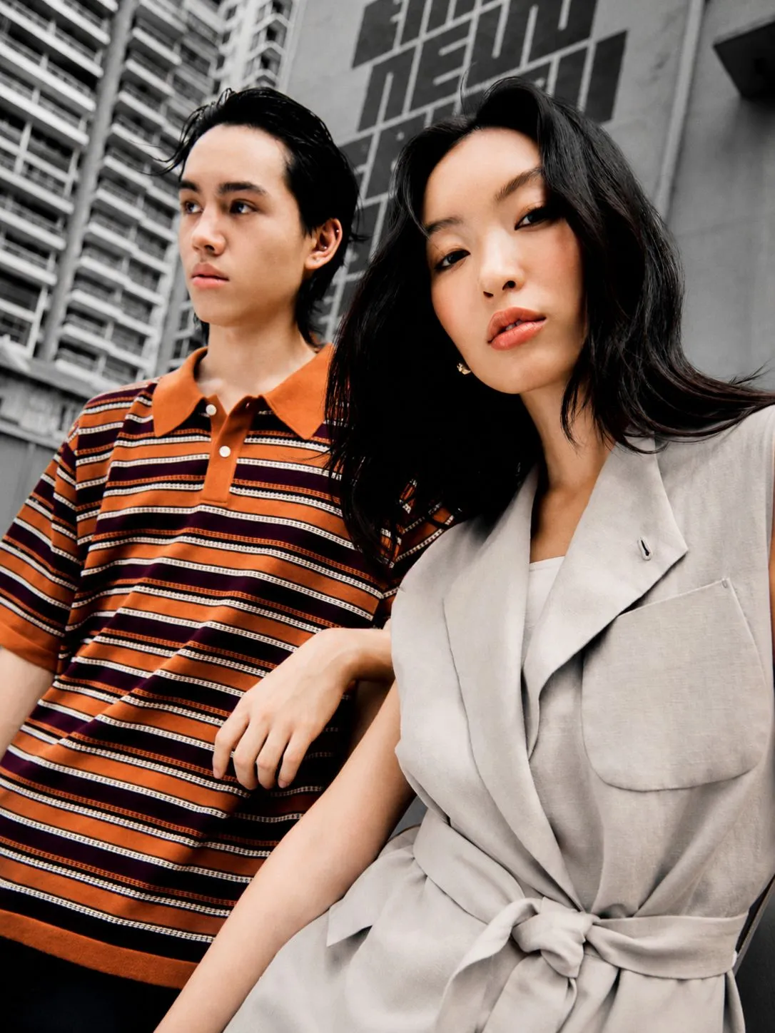 Two young Singaporeans in a city street, with an orange striped shirt picked out against a largely monochrome scene