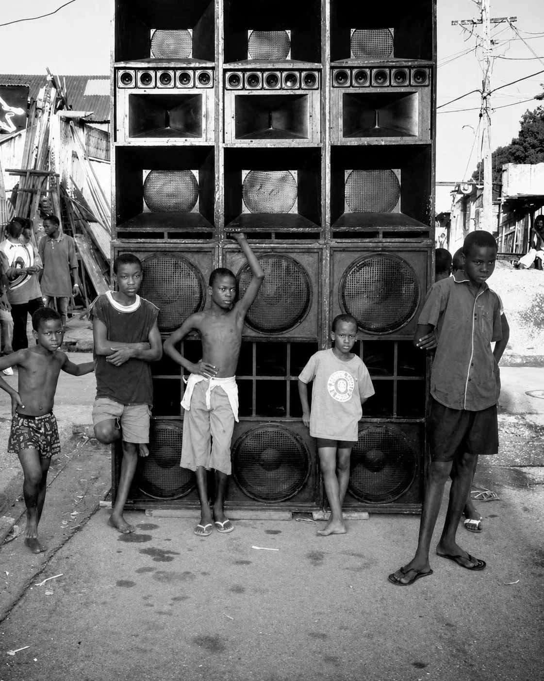 Children standing in front of a towering Jamaican sound system in a neighbourhood street